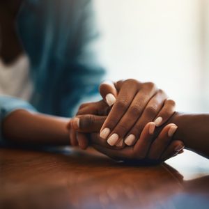 closeup shot of two people holding hands in comfort