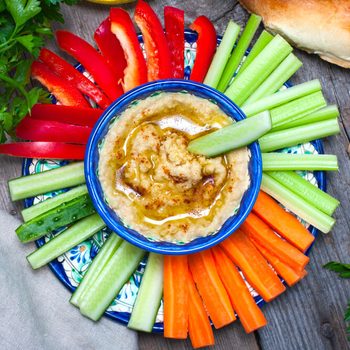 Homemade hummus with fresh vegetables, top view