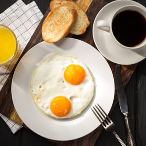 Fried eggs with toasts and coffee on the table