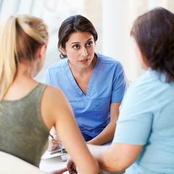 Nurse Meeting With Teenage Girl And Mother In Hospital