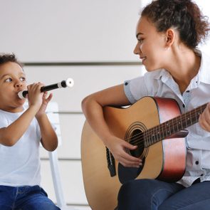 Young girl and little boy playing on music instruments