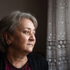 portrait of senior woman looking out the window