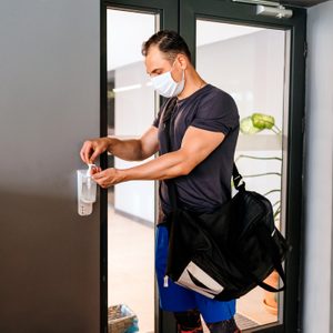 man using hand sanitizer at gym