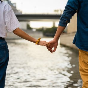 France, Paris, couple holding hands at river Seine