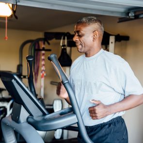 Black man running on treadmill in garage