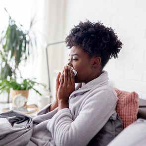 Woman lying in bed with virus and high temperature