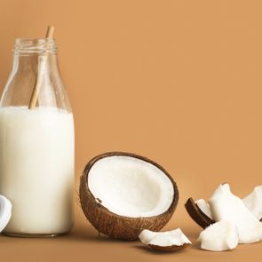 A bottle of coconut milk and pieces of coconut