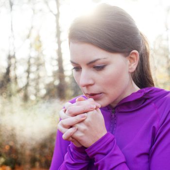 Woman warming hands on cold day.