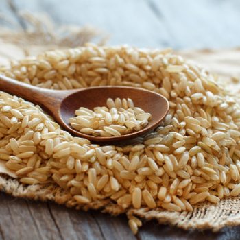 Pile of Brown rice with a wooden spoon