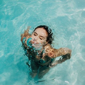 Young woman coming up from being submersed underwater