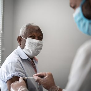 mature man receiving a vaccine shot from doctor