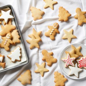 Christmas sugar cookies being iced, overhead view