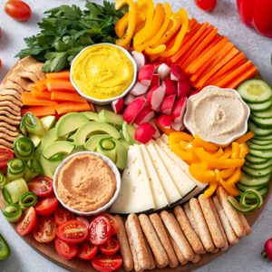 Colorful vegan Charcuterie board with raw vegetables and whole wheat snacks