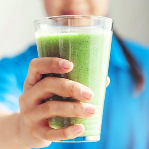 Midsection Of Woman Holding a green Smoothie