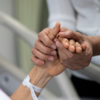 Shot of daughter encourage her mother and holding the mother's hand to sleep on the bed ​in hospital.